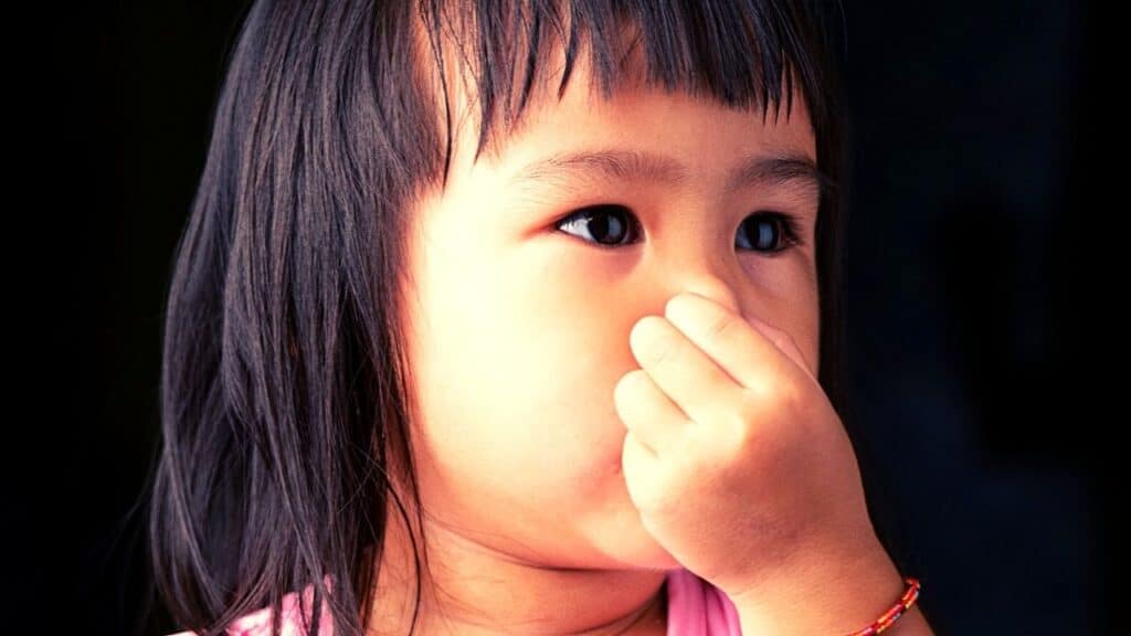 girl holding nose due to bad smell